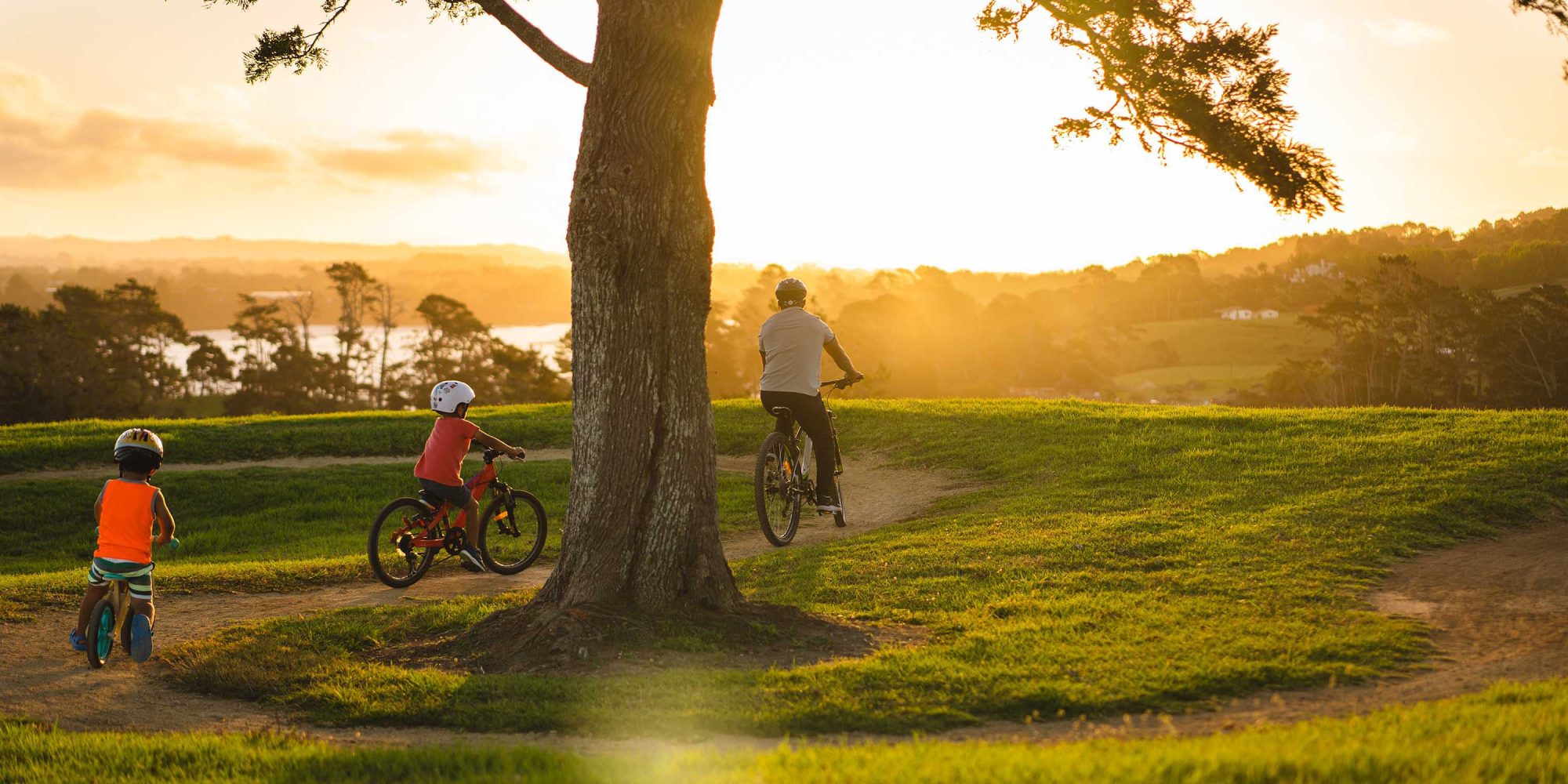 Kids following father on bike.