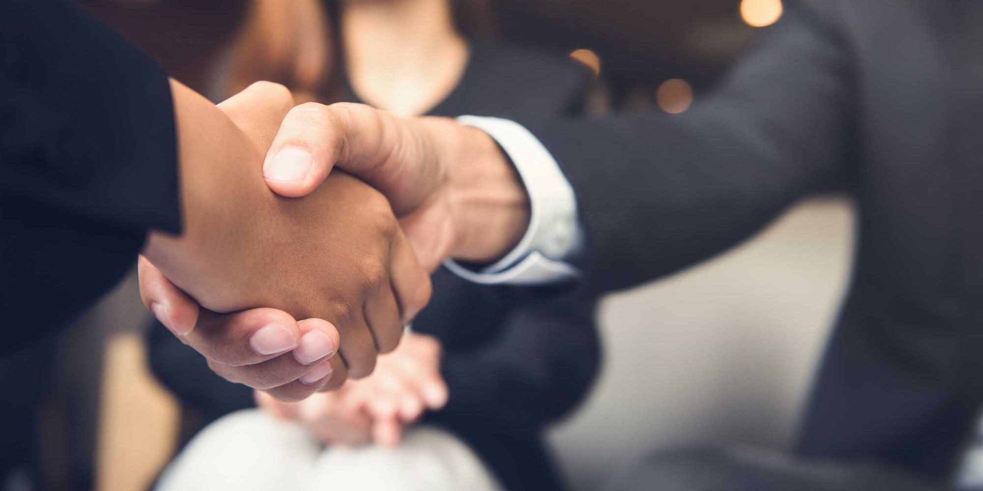 Businessmen shaking hands after meeting in a cafe