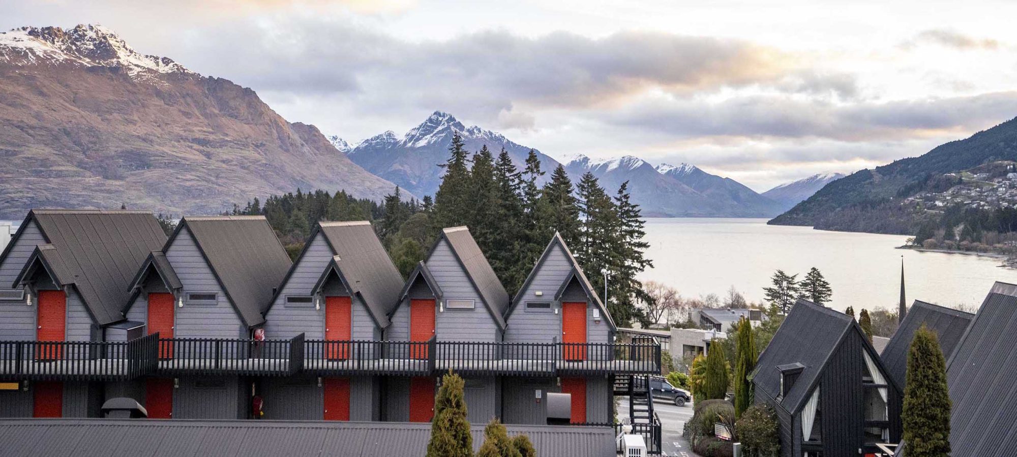 Heartland-Hotel-Queenstown-Rooms-Exterior-Lake-Mountain-Views-Sunset-Snow-Banner