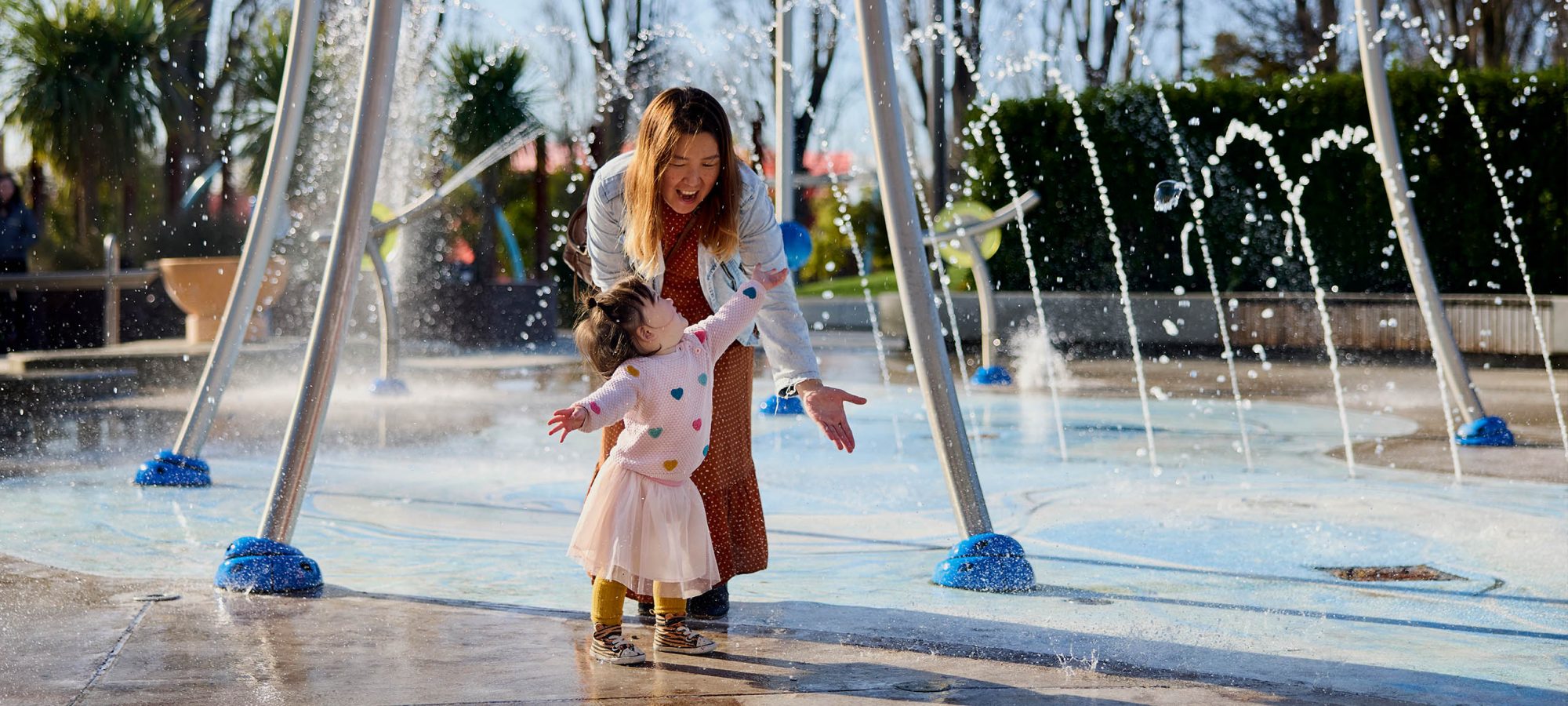 Margaret-Mahy-Playground-Mother-and-Girl-playing-under-water-fountain-credit-Christchurch-Tourism-Banner