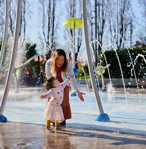 Margaret-Mahy-Playground-Mother-and-Girl-playing-under-water-fountain-credit-Christchurch-Tourism-Small