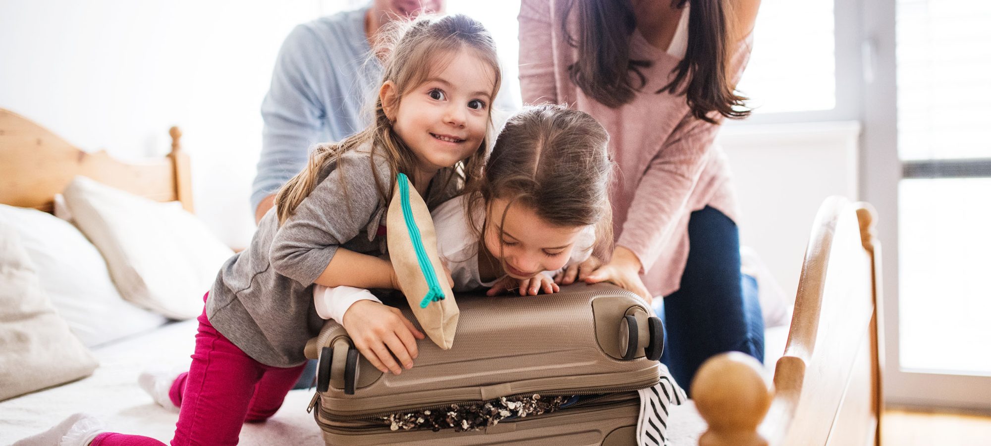 Two_daughters_parents_packing_suitcase_website_banner