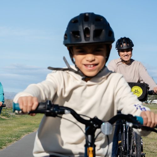 Coffee and Crayons 2 children and a mother riding bikes towards the camera looking happy